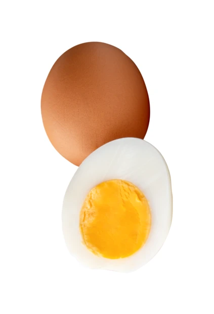 Whole brown chicken egg and sliced hard boiled egg