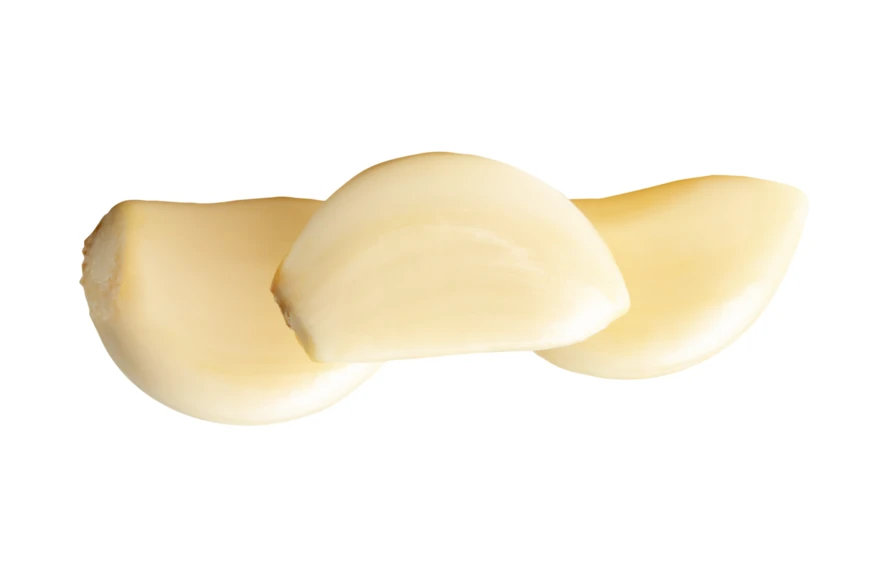 Three peeled garlic cloves isolated on white background