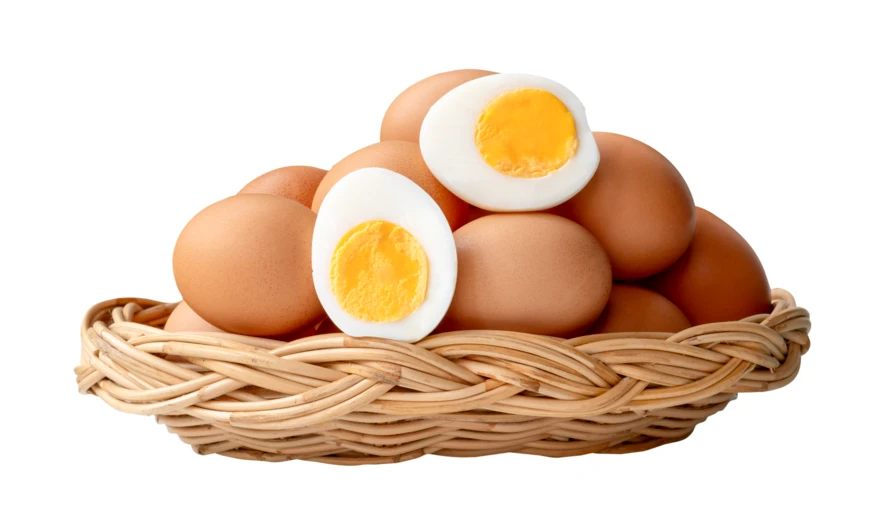 Brown chicken eggs and boiled egg halves in wicker basket