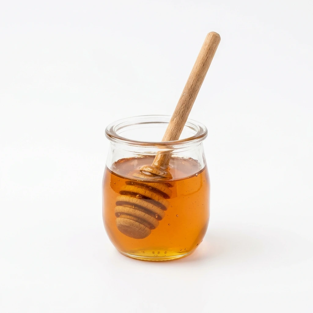Small glass jar of honey with wooden dipper