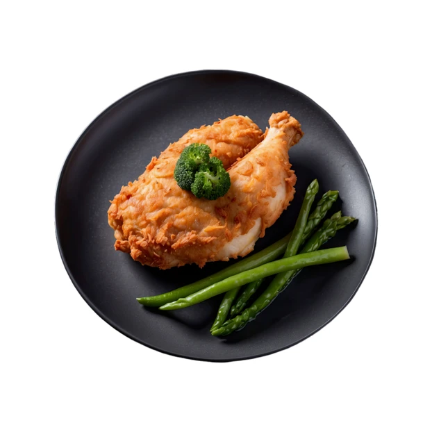Crispy fried chicken with asparagus and broccoli on black plate