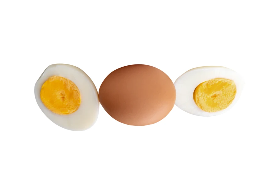 Whole brown egg and hard boiled egg halves on white