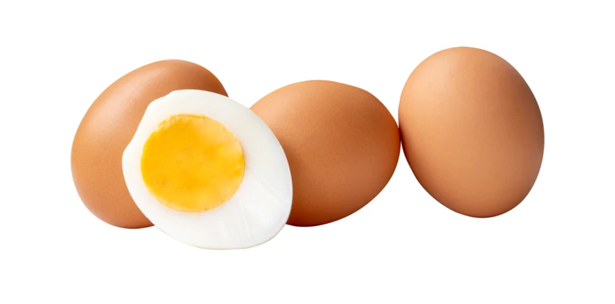 Three whole brown eggs and one sliced hard-boiled egg