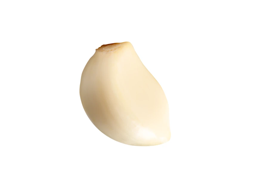 Single peeled garlic clove isolated on white background