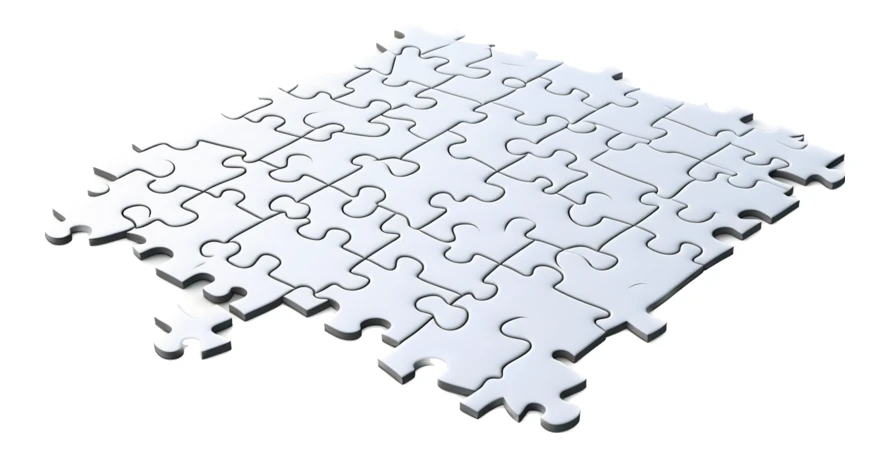 Partially assembled white jigsaw puzzle on white background