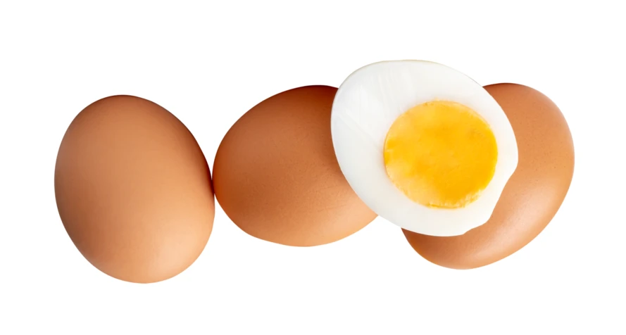 Group of brown eggs with one sliced hard-boiled egg