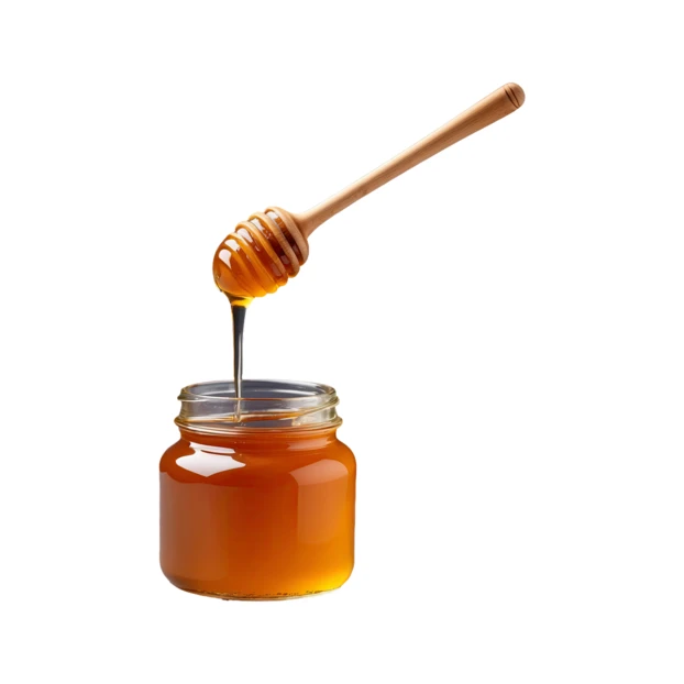 Fresh honey dripping from a wooden dipper into a jar
