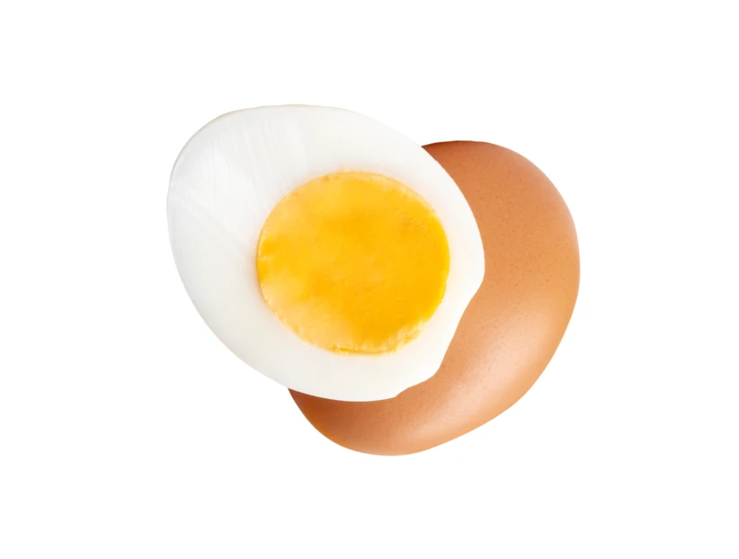Hard-boiled egg half on a whole brown egg
