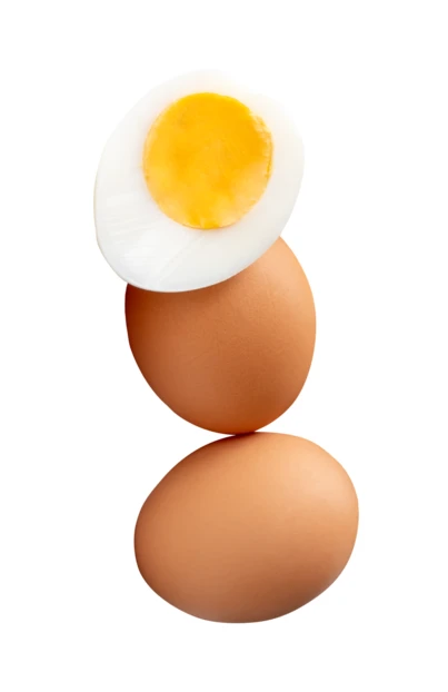 Vertical stack of brown chicken eggs and boiled egg half