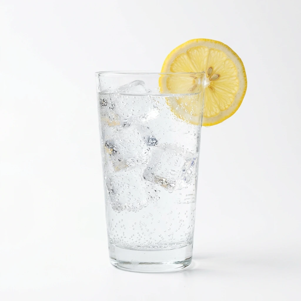 Glass of sparkling water with ice and lemon slice