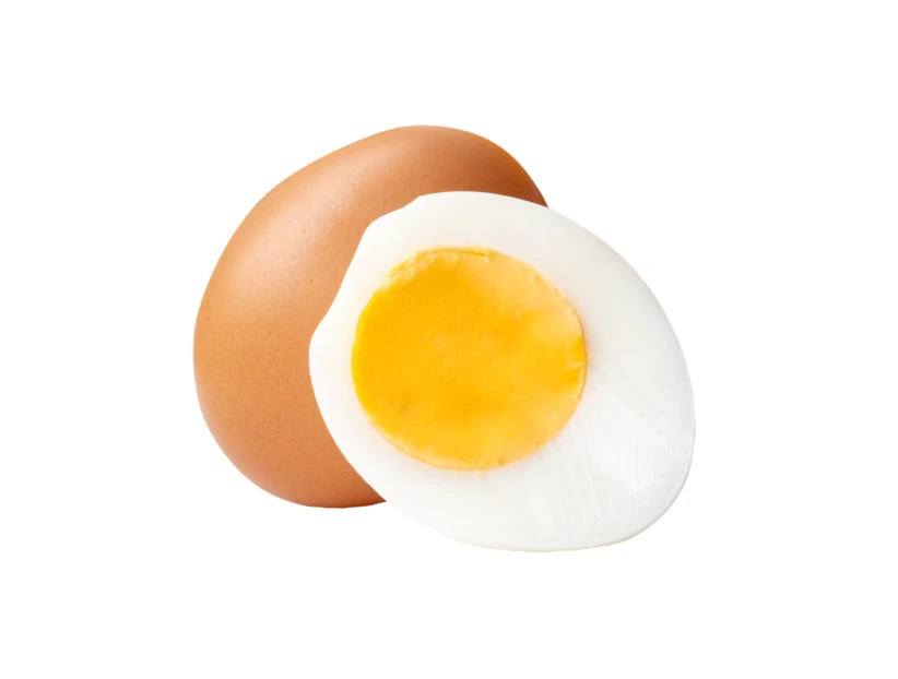 Whole brown egg and half hard-boiled egg on white