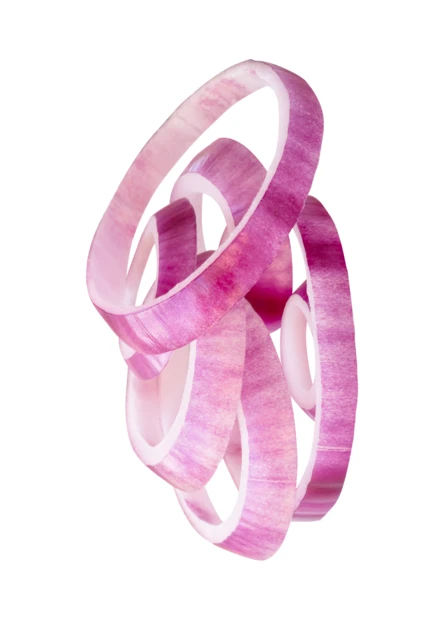 Slices of red onion rings falling on white background