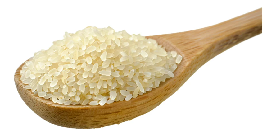 White rice grains in a wooden spoon isolated on white