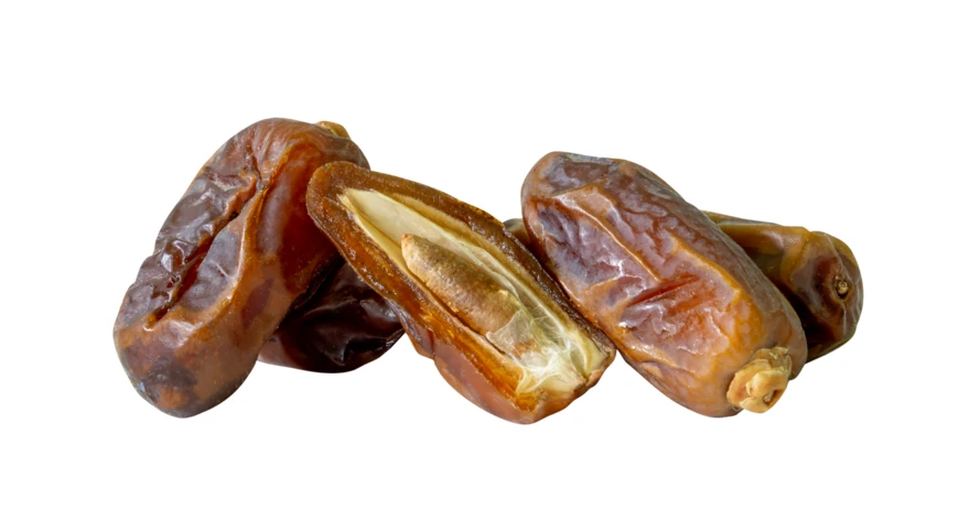 Dried dates and one halved date on white background