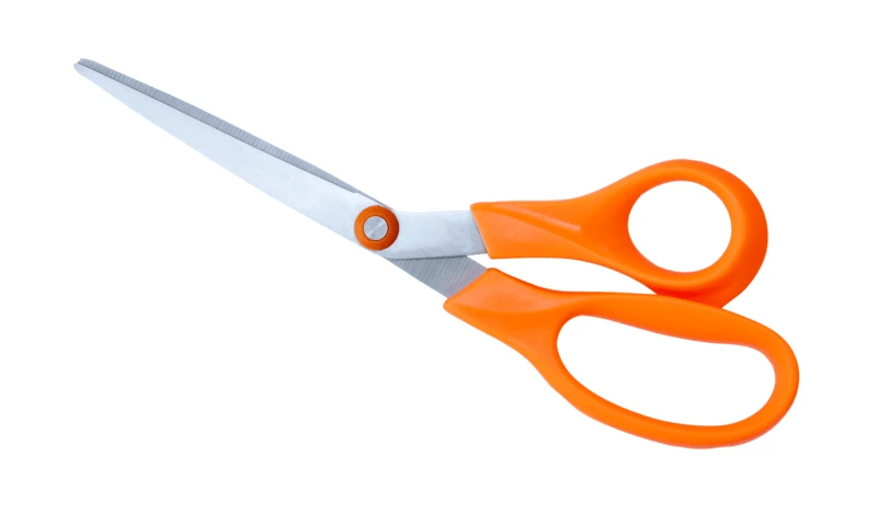 Open scissors with orange handles isolated on white background