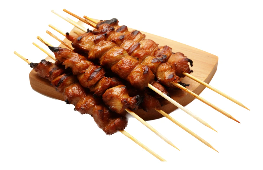 Grilled meat skewers on wooden board isolated on white