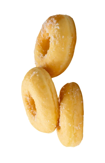Three mini sugar donuts falling against a white background