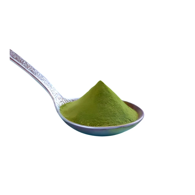 Green matcha tea powder on a spoon isolated on white