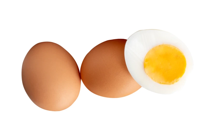 Two whole brown eggs and one hard-boiled egg half