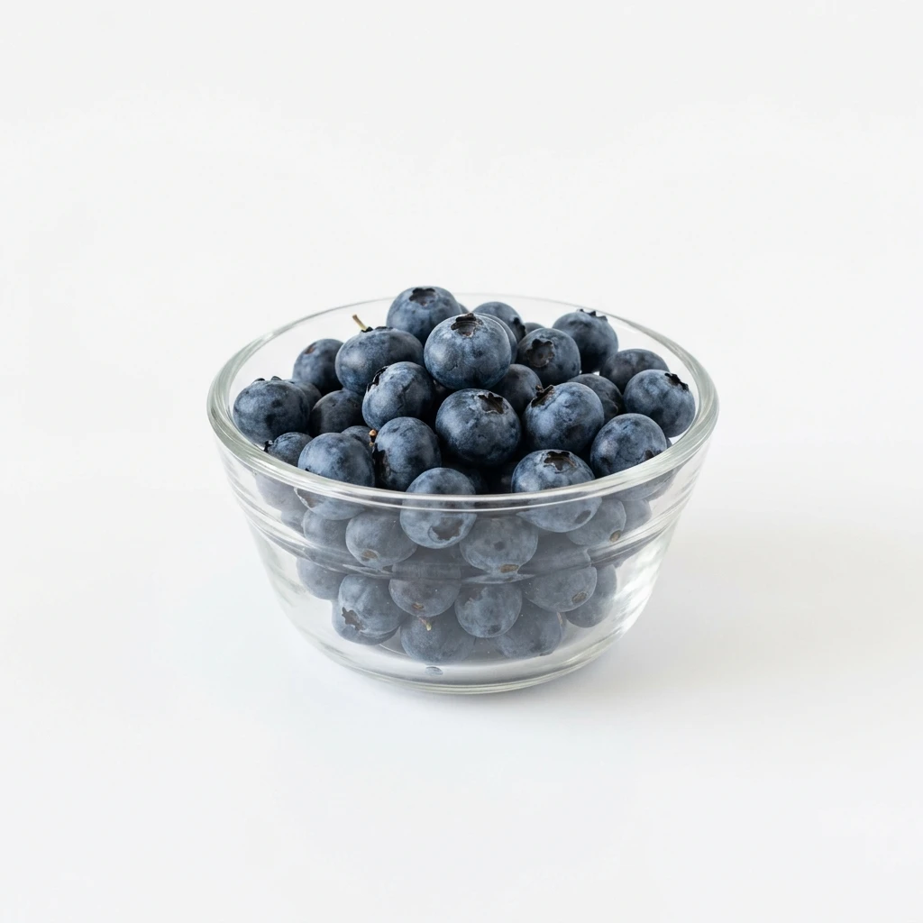 Fresh blueberries in a clear glass bowl on white background