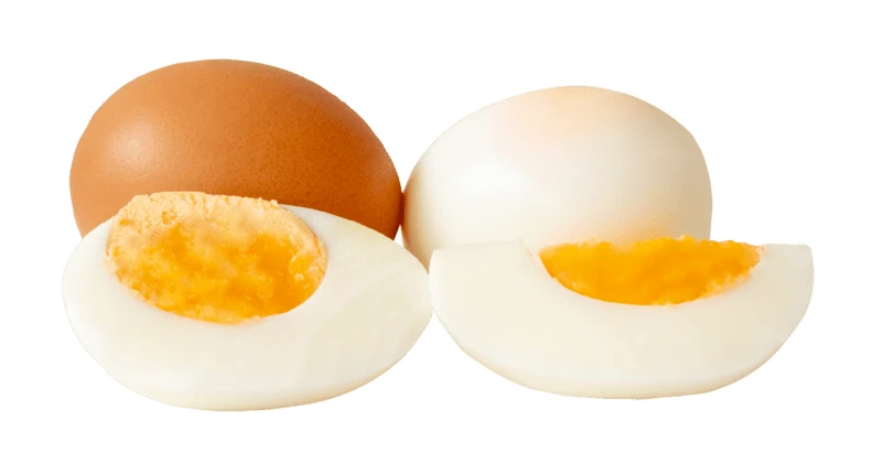 Whole and sliced hard boiled eggs on white background
