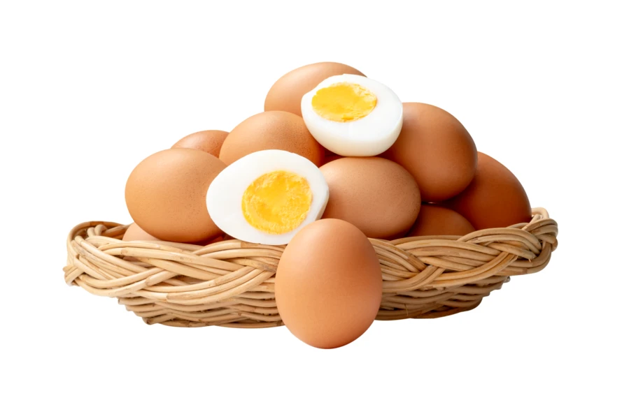 Fresh brown chicken eggs and boiled halves in wicker basket