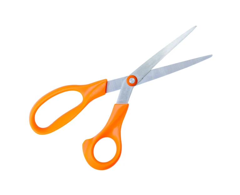 Pair of scissors with orange handles on white background