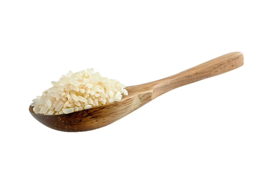 White rice grains in a wooden spoon isolated on white