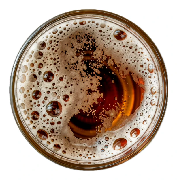 Top view of a glass of dark beer with foam