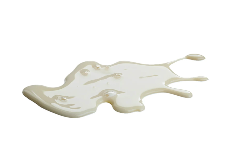 Spilled white cream or condensed milk on white background