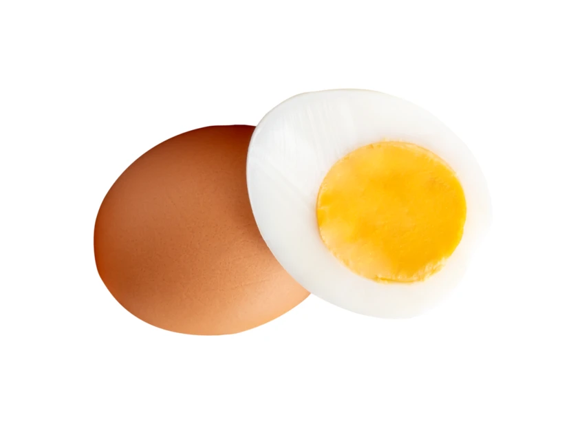 Whole brown egg and half hard-boiled egg on white