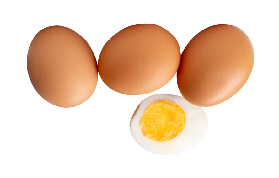 Three whole brown eggs and one hard-boiled egg half